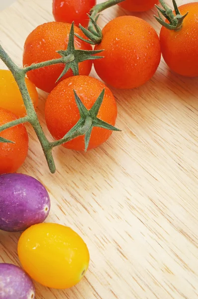 Branch of red ripe cherry tomatoes on a wooden board — Stock Photo, Image