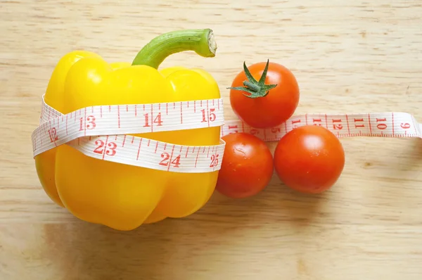 Envoltura de pimiento amarillo con cinta métrica y tomates (concepto de dieta ) —  Fotos de Stock