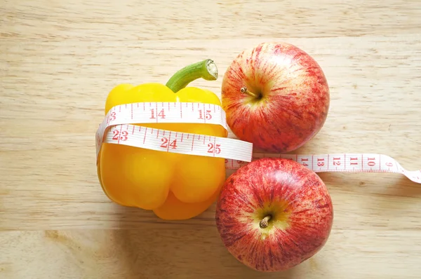 Овощная диета. Желтый перец с мерной лентой и яблоком — стоковое фото