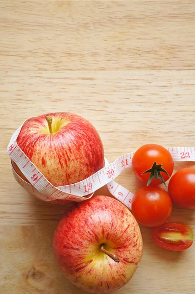Envoltura de manzana roja con cinta métrica y tomates (concepto de dieta ) —  Fotos de Stock