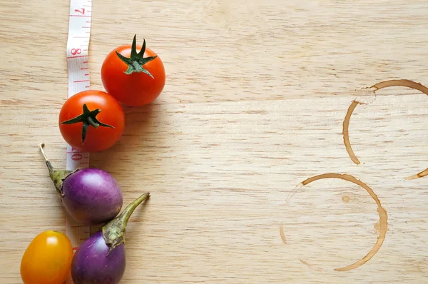 Tomates frescos com mancha de café na mesa de madeira — Fotografia de Stock