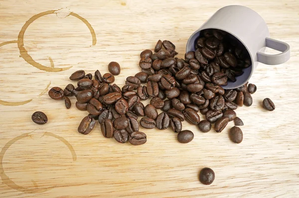 Granos de café con mancha sobre fondo de madera — Foto de Stock