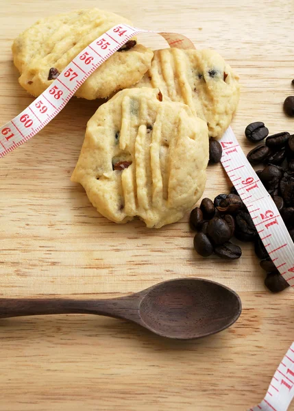 Galletas bajas en grasa en mesa de madera con grano de café —  Fotos de Stock