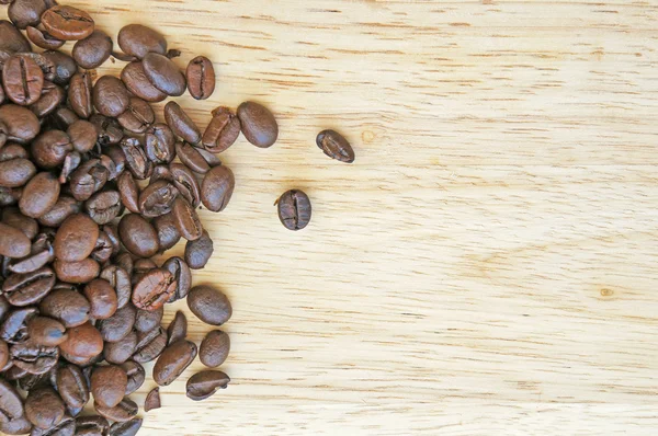 Granos de café sobre fondo de madera — Foto de Stock