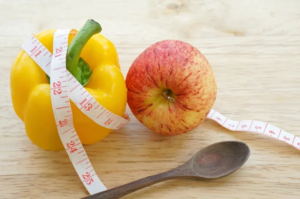 Vegetable diet. Yellow bell pepper with measuring tape and apple — Stock Photo, Image