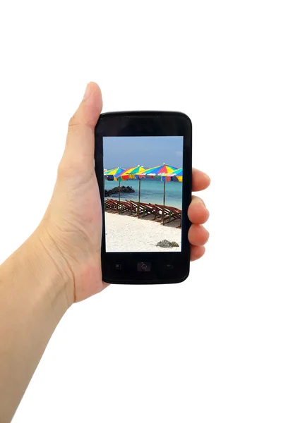 Teléfono móvil en la mano con mar de playa aislado en blanco — Foto de Stock