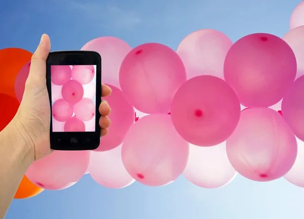 Med rosa ballonger foto med smart telefon — Stockfoto