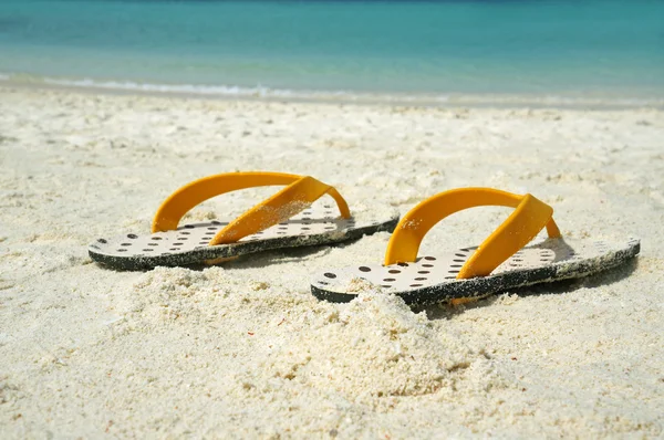 Sommerurlaub Hintergrund mit einem Paar Sandalen am Strand — Stockfoto