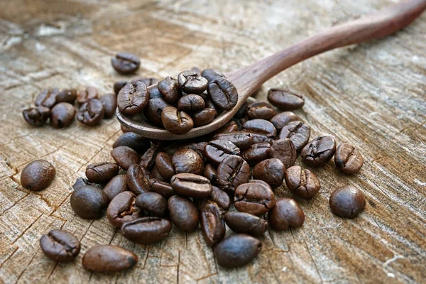 Kaffeebohnen auf altem Holzgrund — Stockfoto