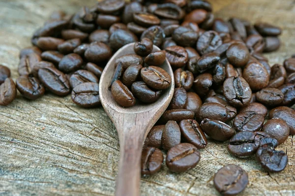 Kaffeebohnen auf altem Holzgrund — Stockfoto