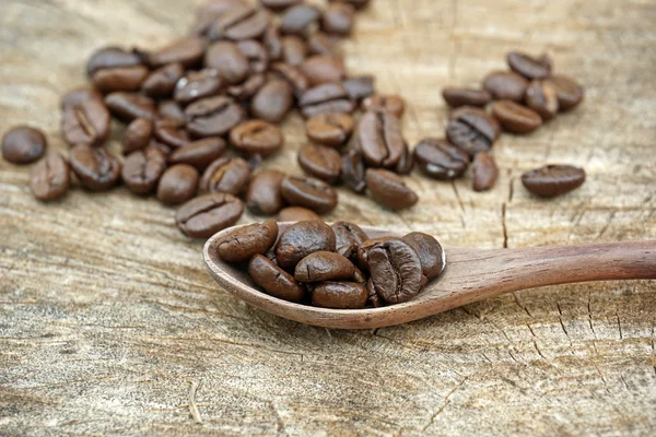 Grãos de café em um velho fundo de madeira — Fotografia de Stock