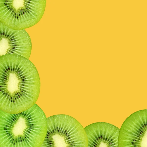 Kiwi fruit slices on a yellow background — Stock Photo, Image