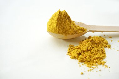 beyaz zemin üzerine kaşık üzerinde zerdeçal