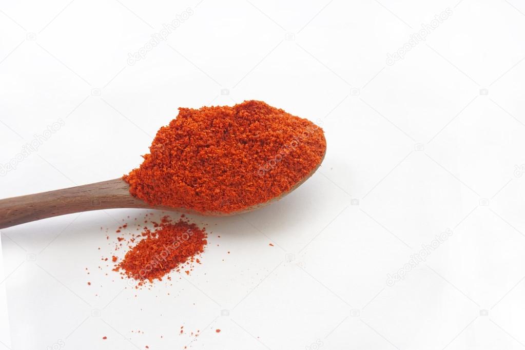 Spoon of red chili powder isolated on white background