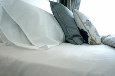 beyaz yatak odası ile bir yatak ve yastıklar.