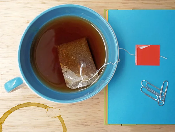 Primer plano de la bolsa de té y la taza en la mesa de madera — Foto de Stock