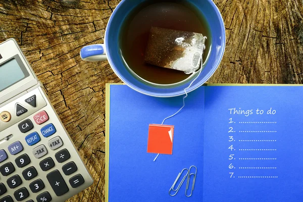 Schreibwaren, Taschenrechner, Kaffeetasse, Notizbuch mit Aufgabenliste — Stockfoto