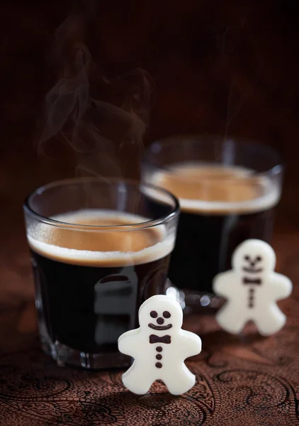 Hot espresso and white chocolate candy men — Stock Photo, Image