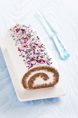 Roll cake with black tea, spices and dried flower petals clipart