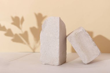 Kozmetik ürünler için betondan yapılmış geometrik şekilli arka plan. Bej arka planı gölgeli dikdörtgen podyumlar. Ürün paketleme sunumu için boş model