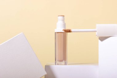 Temel, geometrik şekillerin arka planında kapatıcı. Bej arkaplanda fotokopi alanı olan yüz düzeltici. Kopyalama alanı olan paketleme modeli