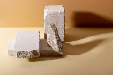 Kozmetik ürünler için betondan yapılmış geometrik şekilli arka plan. Bej arka planı gölgeli dikdörtgen podyumlar. Ürün paketleme sunumu için boş model