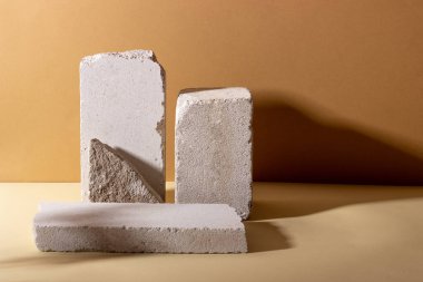 Kozmetik ürünler için betondan yapılmış geometrik şekilli arka plan. Bej arka planı gölgeli dikdörtgen podyumlar. Ürün paketleme sunumu için boş model