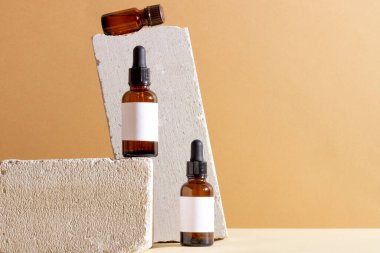 Cam bir şişede, beton bir kürsüde pipetle yüz ve vücut bakım ürünleri. Doğal malzemeleri olan kadınlar için kozmetik ürünler. Boşluğu, düzeni kopyala