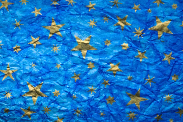 Crumpled blue paper with gold stars