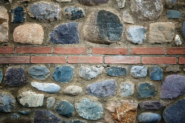 Parede de pedra áspera com decoração de tijolo — Fotografia de Stock
