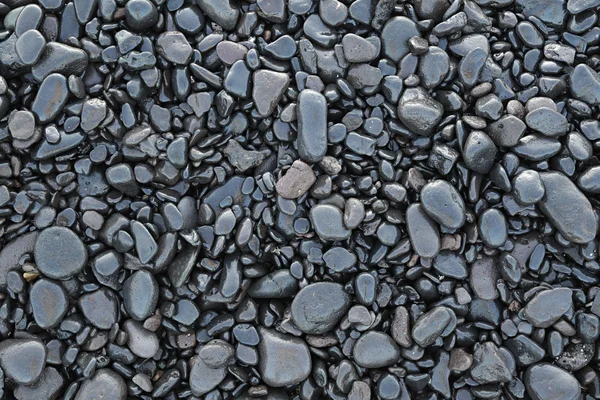 Bakgrund av våta svart pebbles bakgrund av blöta svarta stenar — Stockfoto