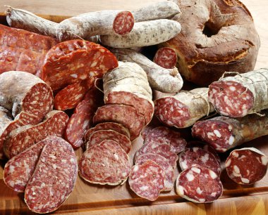 Assortment of different sliced salamis clipart