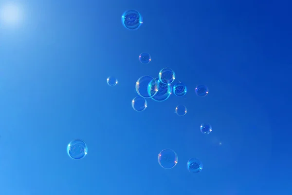 Grupo de burbujas de jabón sobre un fondo azul — Foto de Stock