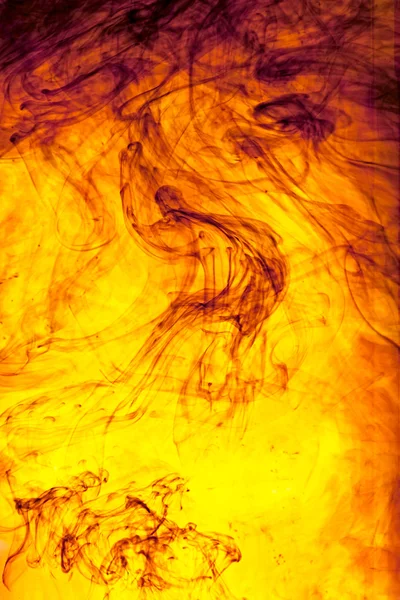 Vrilles colorées tourbillonnantes d'encre dans l'eau — Photo