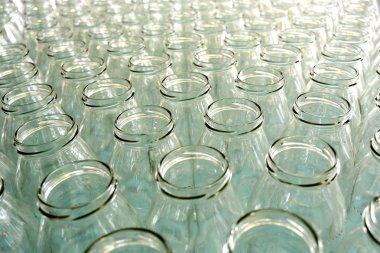 Empty glass bottles in a bottling plant or store clipart