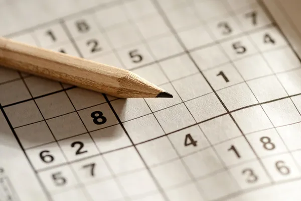 Bleistift liegt auf einem Sudoku-Gitter — Stockfoto