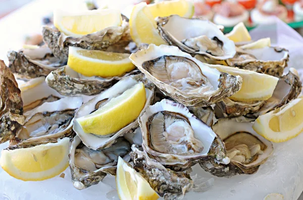 Porción de ostras frescas con limón —  Fotos de Stock