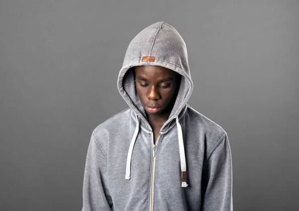 Junger Schwarzer Mann Trägt Einen Grauen Kapuzenpulli Und Blickt Mit lizenzfreie Stockfotos