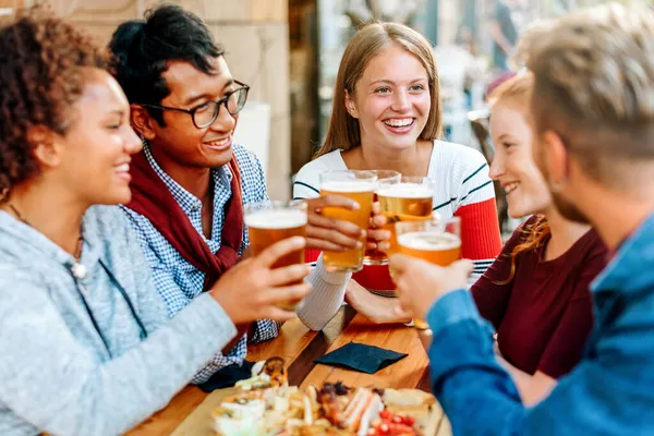 Gruppo Diversi Giovani Amici Che Godono Una Birra Insieme Alzando — Foto Stock