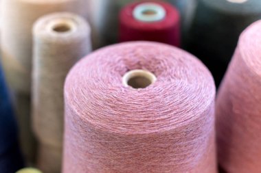 Büyük bir koninin tepesine yakın görüş ya da kopyasıyla örgü fabrikasındaki doğal pembe kaşmir yün makarası.