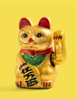 Altın yaldızlı Çinli, Asyalı ya da Feng Shui şanslı bir kedi, sarı arka planda zenginlik ve refahı simgeleyen bir pençesi var.