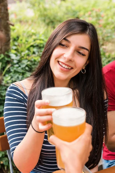 Cheerful Female Clinking Glass Refreshing Beer Unrecognizable Friends While Celebrating — Foto Stock