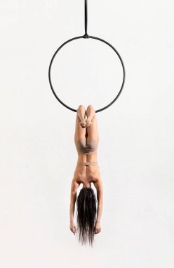 Bat poz ince kadın akrobat ters asılı Bat halka beyaz arka plan karşı poz