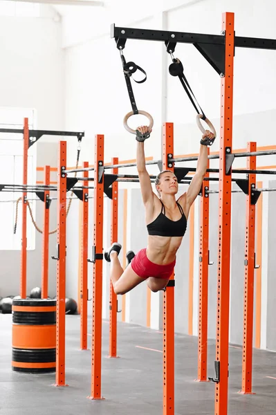 Strong Sportswoman Bra Shorts Swinging Gymnastic Rings While Doing Muscle — 图库照片