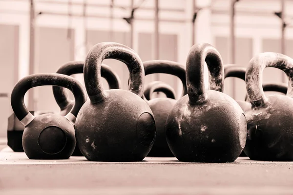 Ground level of many heavy kettlebells for functional workout placed on floor in light gym