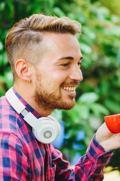 Side View Positive Bearded Male Modern Wireless Headphones Drinking Hot — Stock Photo, Image