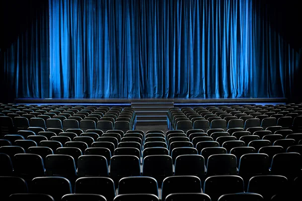 空の映画館や舞台が暗くなり 青いカーテンが後部から空いている席の列の上に描かれています — ストック写真