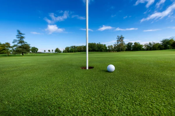 Vit Boll Grönt Gräs Nära Hål Med Flagga Mot Blå — Stockfoto