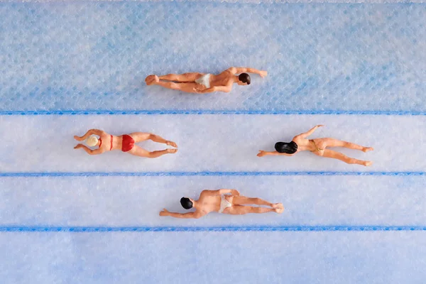 由玩具女和无上衣男组成的顶级观赏组 由塑料制成 在蓝色游泳池中一起游泳 — 图库照片