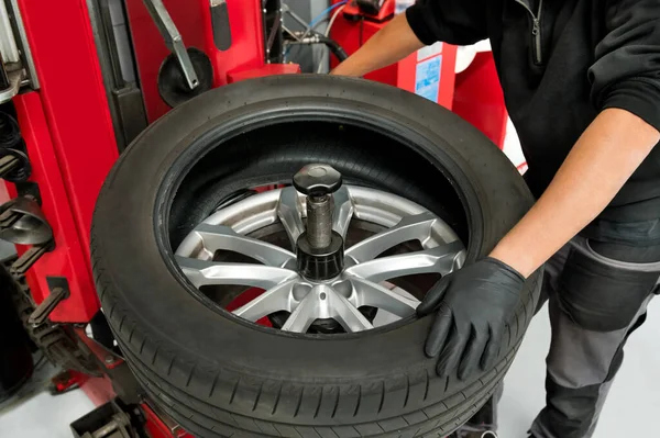 车间使用机械将轮胎从轮毂上卸下的男性机械师的中段 — 图库照片